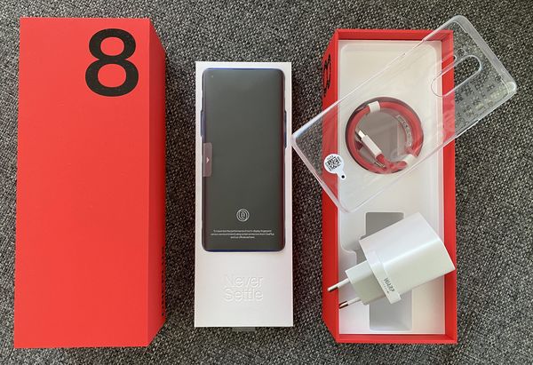 OnePlus 8 Pron myyntipakkauksen sisältö: itse puhelin, läpinäkyvä suojakuori, kaapeli ja Warp Charge 30T -pikalaturi.