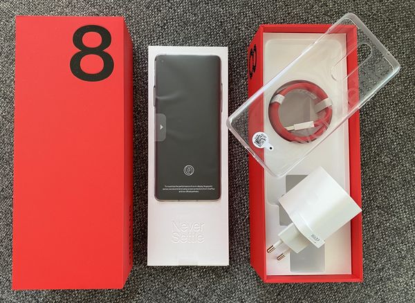 OnePlus 8:n myyntipakkauksen sisältö: itse puhelin, läpinäkyvä suojakuori, kaapeli ja Warp Charge 30T -pikalaturi.