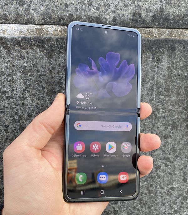 Galaxy Z Flipin näytön taitoskohta erottuu kirkkaassa valossa ja tummalla näytön sisällöllä erittäin selvästi. Reunuksen alakulmissa on kuminystyrät, jotka pehmentävät kannen sulkeutumista.